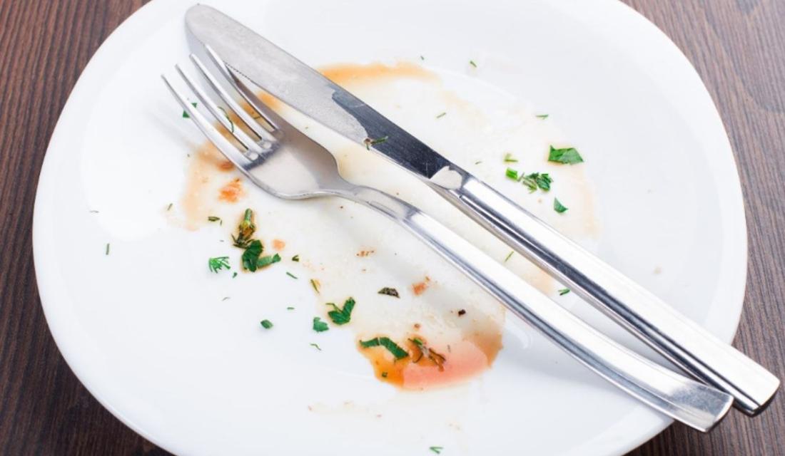 Ein leerer Teller auf dem Besteck liegt