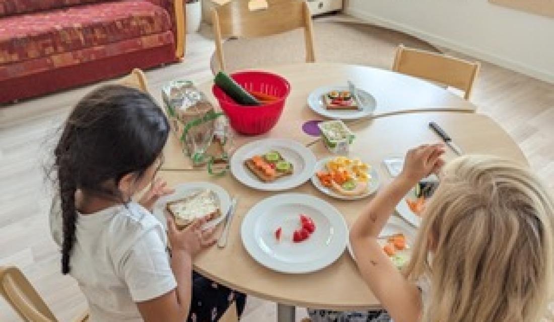 Kinder sitzen am Frühstückstisch