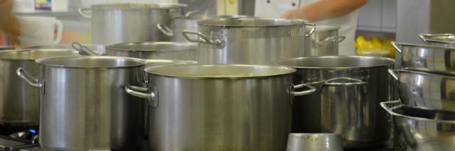 Koch rührt in Kochtöpfen 