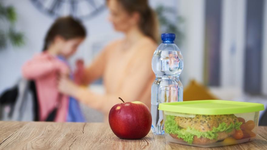 Kind geht zur Schule, dazu Wasser und Pausenbrot