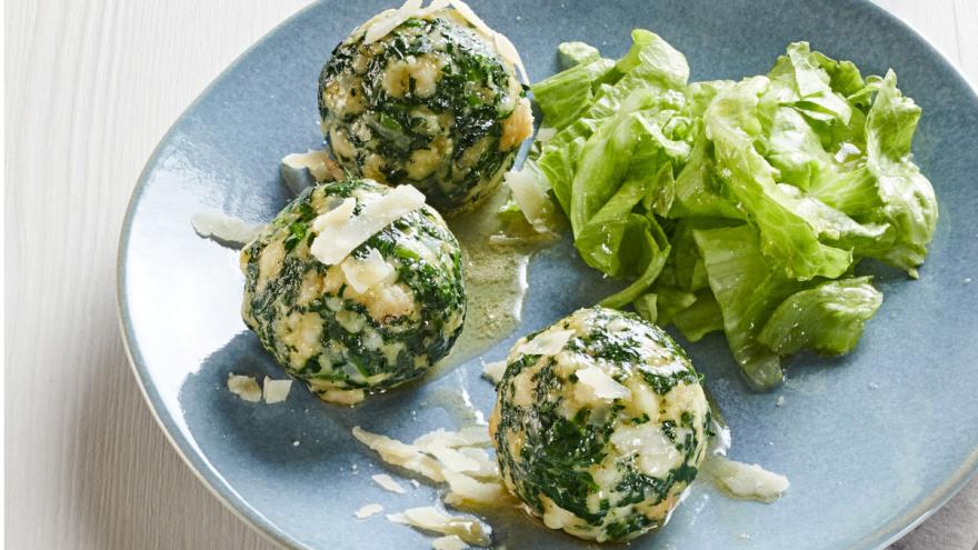 Spinatknödel mit Eisbergsalat auf einem Teller