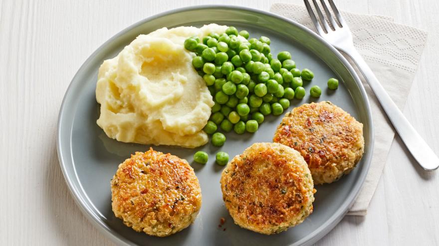 Vegetarische Frikadellen mit Kartoffelpüree und Erbsen auf einem Teller