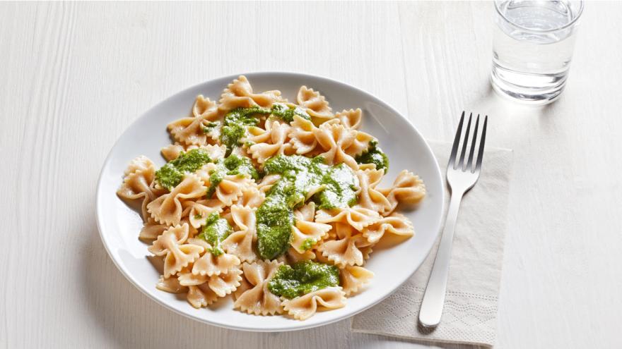 Vollkornpasta mit selbstgemachtem Basilikumpesto auf tiefem Teller