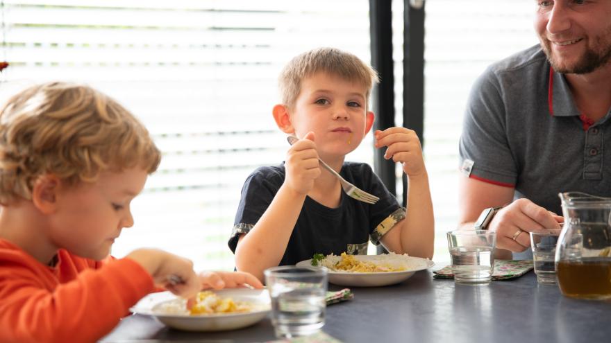 Kinder mit Mann am Tisch