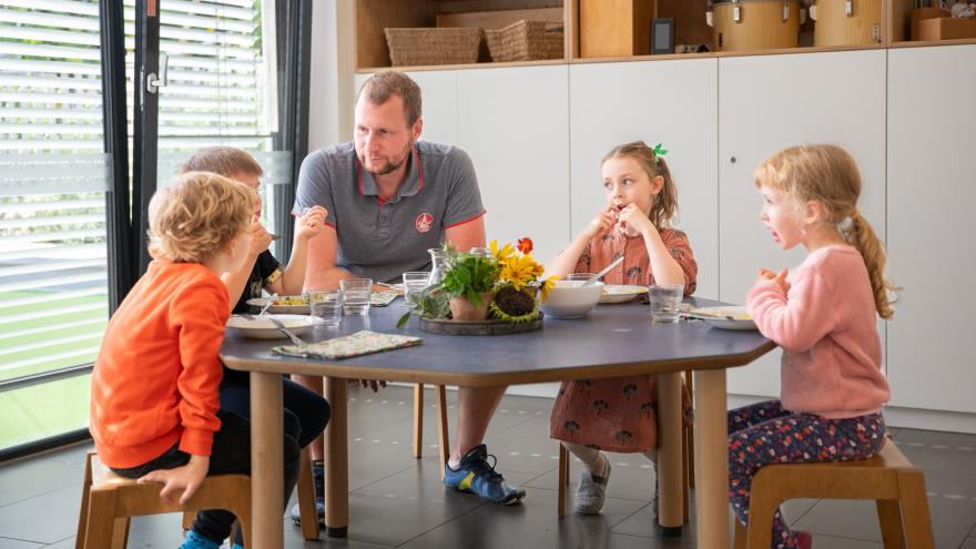 Bildungsort Esstisch mit Kinder und Erwachsenen am Tisch