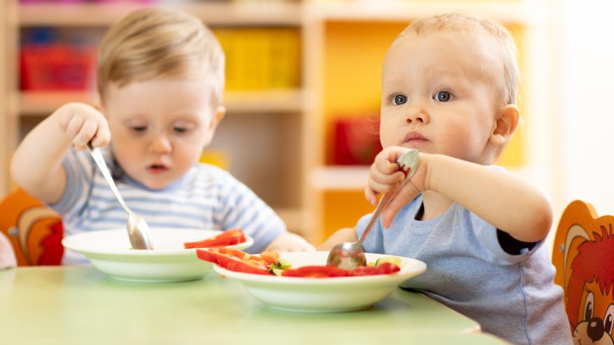 zwei Kleinkinder am Tisch mit Essen