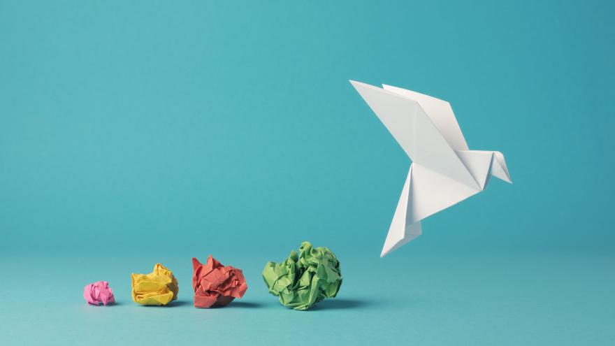 Bunte zerknüllte Papierkugeln mit einer Papiertaube, die zum Start ansetzt, Chancen nutzen