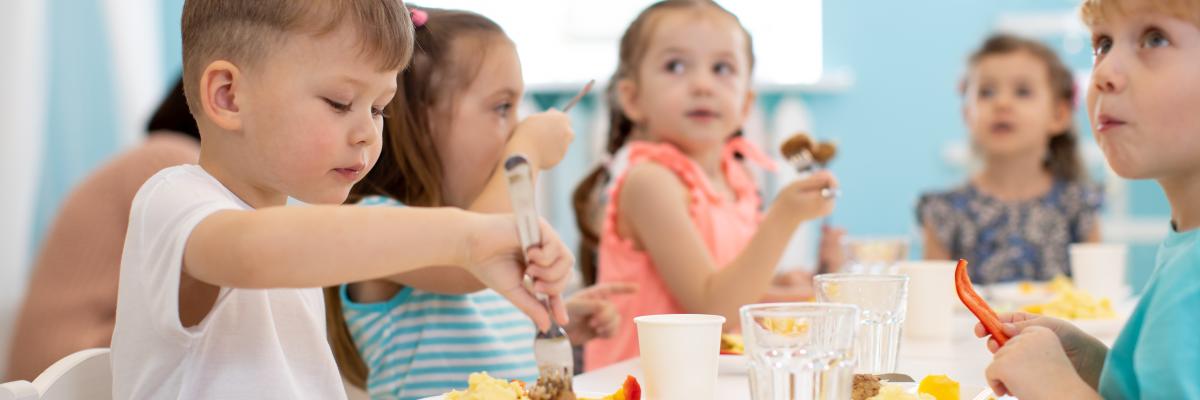 Eine Gruppe von Kindern genießt das gesunde Mittagessen im Kindergarten.