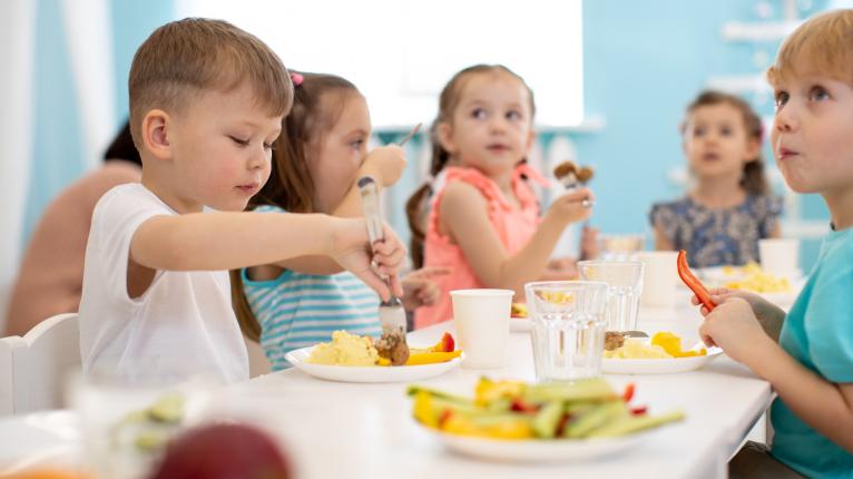 Eine Gruppe von Kindern genießt das gesunde Mittagessen im Kindergarten.