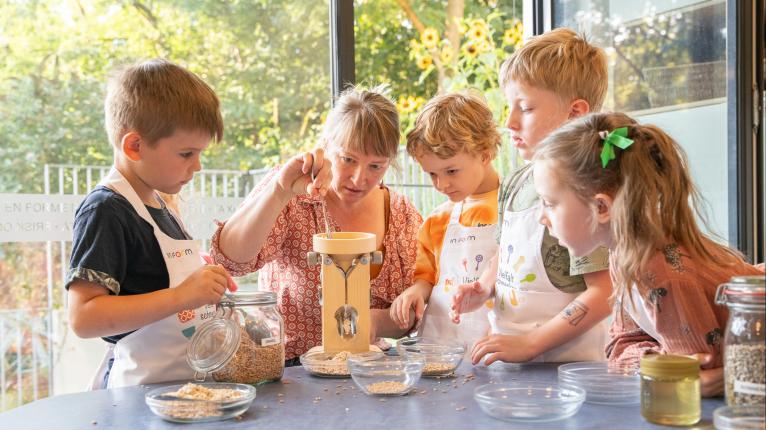 Ernährungsbildungsaktion mit einer Gruppe von Kindern mit einer Flockenquetsche.